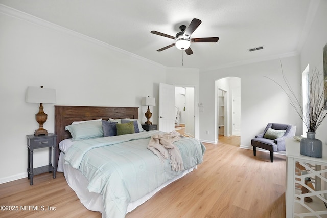 2012 Belle Grove Ter, Fleming Island, FL 32003 - bedroom with arched walkways, light wood-style flooring, baseboards, crown molding, and a ceiling fan