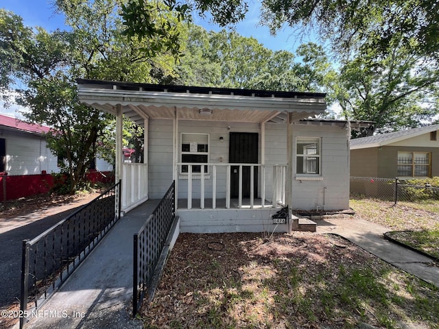 view of front of house with covered porch and fence