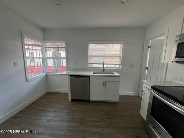 kitchen featuring a sink, appliances with stainless steel finishes, dark wood-style flooring, and healthy amount of natural light