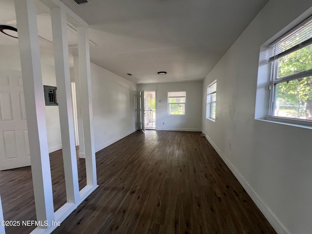 spare room featuring dark wood-style flooring and baseboards