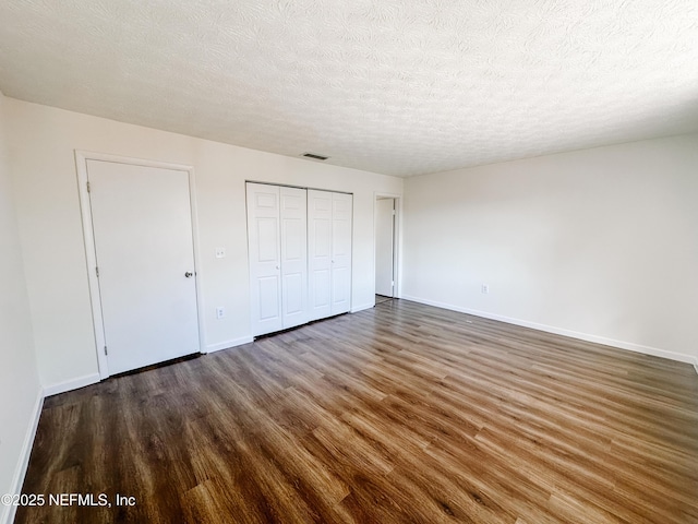5201 Atlantic Blvd Unit 299, Jacksonville, FL 32207 - unfurnished bedroom featuring wood finished floors, baseboards, a textured ceiling, and a closet
