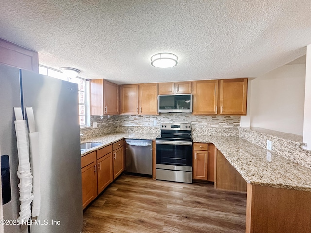 5201 Atlantic Blvd Unit 299, Jacksonville, FL 32207 - kitchen featuring stainless steel appliances, wood finished floors, a peninsula, tasteful backsplash, and a textured ceiling