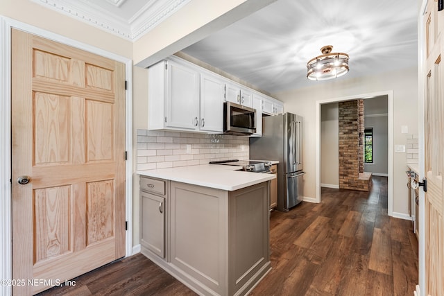 1835 Powder Springs Dr, Jacksonville, FL 32225 - kitchen with appliances with stainless steel finishes, tasteful backsplash, a peninsula, dark wood finished floors, and crown molding