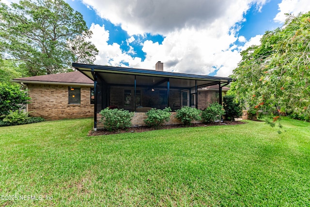 1835 Powder Springs Dr, Jacksonville, FL 32225 - back of house with a chimney, a sunroom, a yard, and brick siding