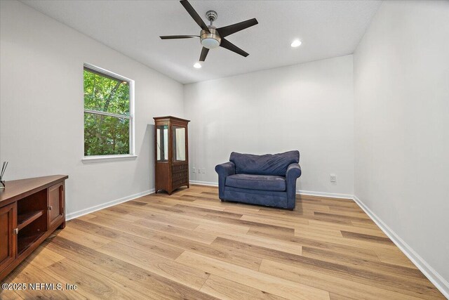 living area with light wood-style floors, a ceiling fan, recessed lighting, and baseboards