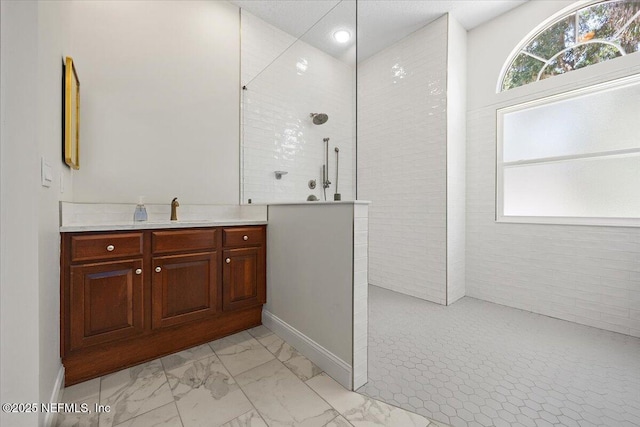 full bathroom with marble finish flooring, a walk in shower, vanity, baseboards, and recessed lighting