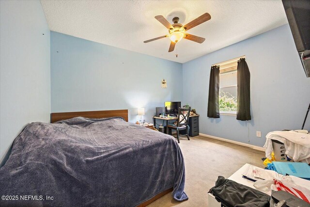 carpeted bedroom with ceiling fan and baseboards