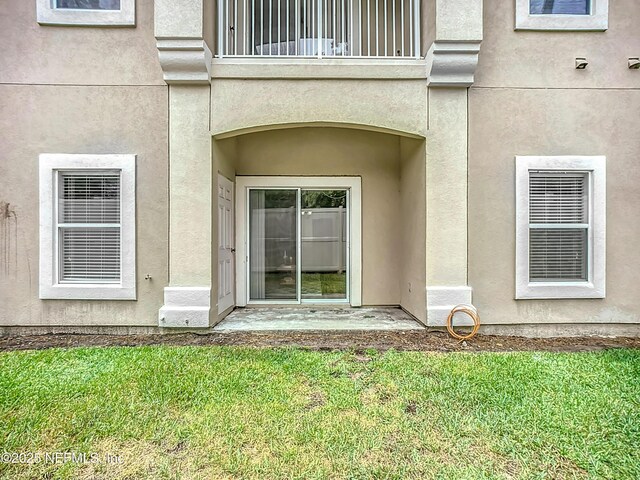 9421 Osprey Branch Trl Unit 2-3, Jacksonville, FL 32257 - property entrance with a balcony, stucco siding, and a lawn