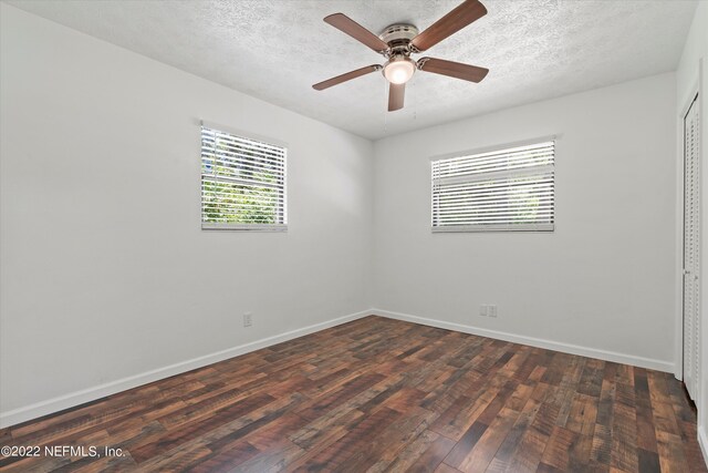 5092 Harvey Grant Rd, Fleming Island, FL 32003 - spare room with healthy amount of natural light, dark wood-type flooring, a ceiling fan, a textured ceiling, and baseboards