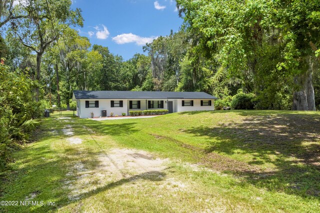 5092 Harvey Grant Rd, Fleming Island, FL 32003 - view of front of house with a front yard and a view of trees