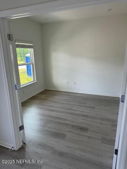 spare room featuring wood finished floors and baseboards