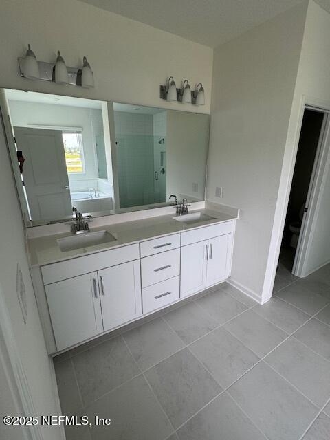 bathroom featuring a stall shower, tile patterned floors, double vanity, and a garden tub