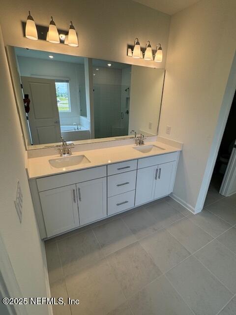 full bath with a shower stall, a garden tub, tile patterned flooring, double vanity, and baseboards