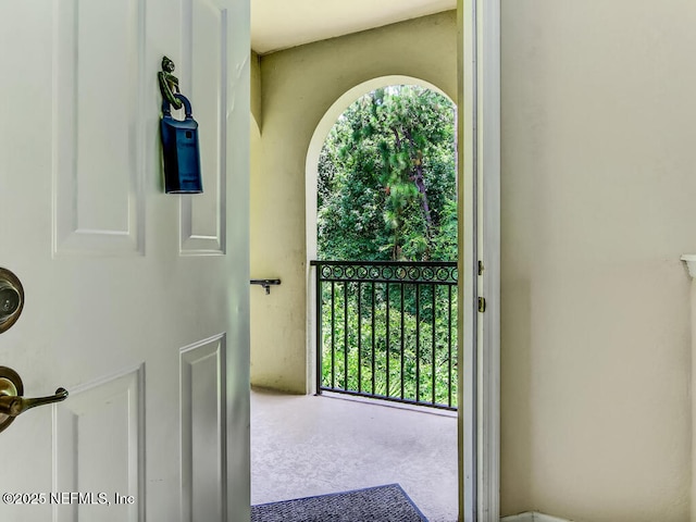 doorway to outside featuring healthy amount of natural light and carpet flooring