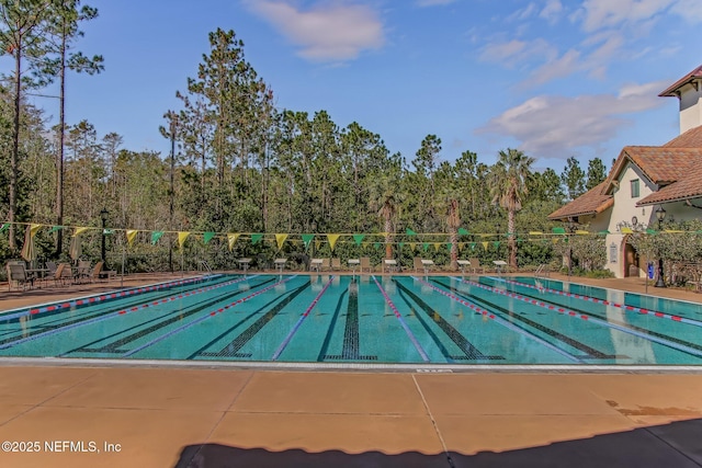 community pool featuring fence and a patio