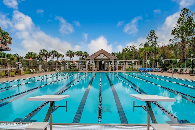 community pool with fence and a diving board