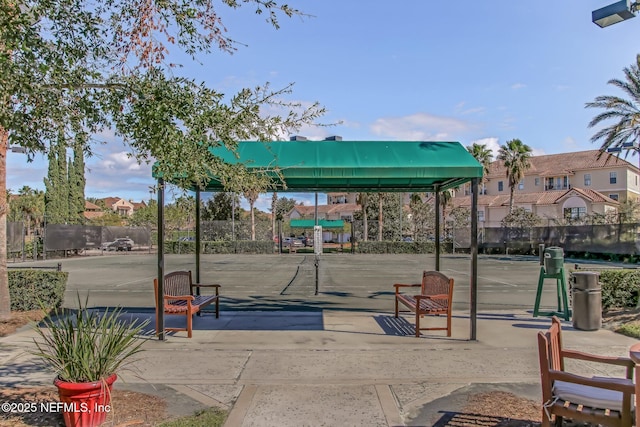 view of property's community with fence and a tennis court