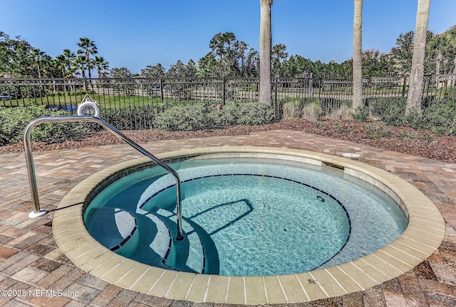 view of swimming pool featuring fence and a hot tub