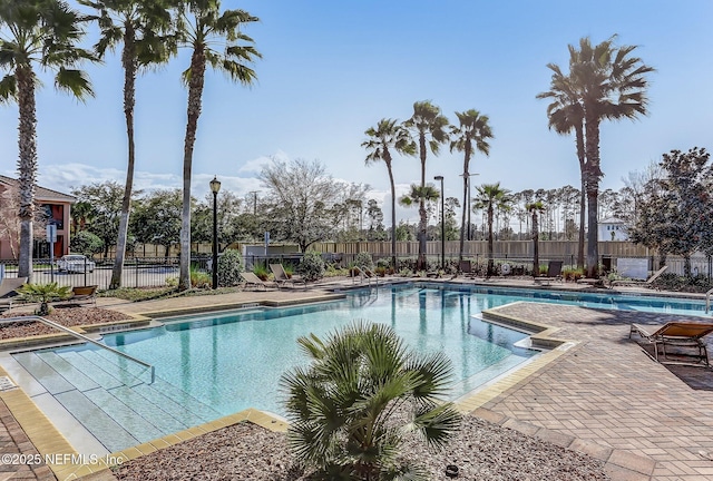 community pool with fence and a patio