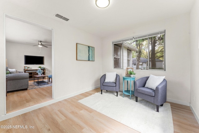 sitting room with wood finished floors, baseboards, and ceiling fan