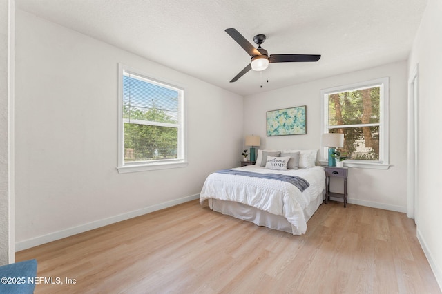 bedroom with wood finished floors, baseboards, and ceiling fan