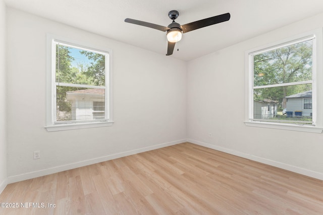 spare room with plenty of natural light, light wood-style floors, baseboards, and ceiling fan