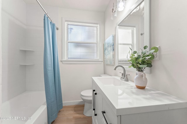bathroom with wood finished floors, toilet, vanity, shower / tub combo with curtain, and baseboards