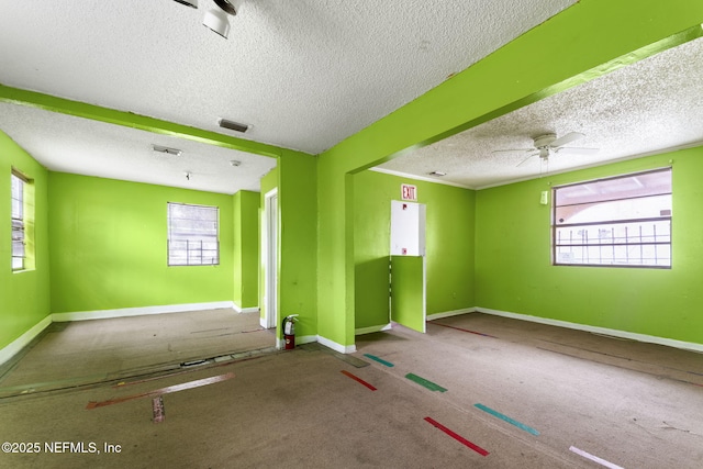 1403 Myrtle Ave N, Jacksonville, FL 32209 - unfurnished room with a textured ceiling, plenty of natural light, baseboards, ceiling fan, and carpet floors