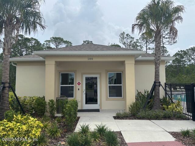 172 Reena Dr, Daytona Beach, FL 32117 - view of front facade with stucco siding, fence, and roof with shingles