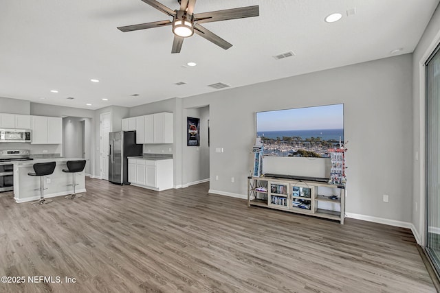 1860 Cogdill, Middleburg, FL 32068 - unfurnished living room with baseboards, light wood finished floors, a ceiling fan, and recessed lighting