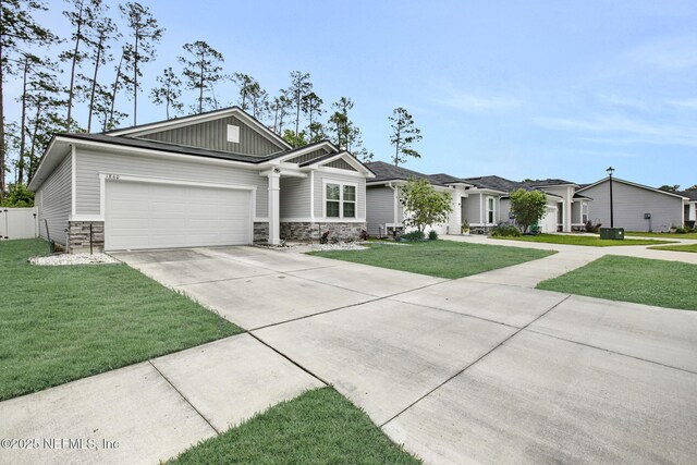 1860 Cogdill, Middleburg, FL 32068 - view of front of home with concrete driveway, a garage, a front yard, stone siding, and board and batten siding