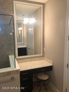 bathroom featuring a shower stall, vanity, and baseboards