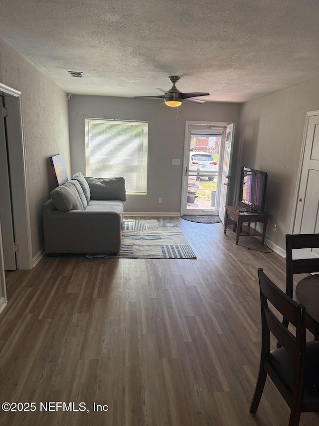 7205 Linda Dr, Jacksonville, FL 32208 - living room featuring a textured ceiling, wood finished floors, a ceiling fan, baseboards, and a textured wall