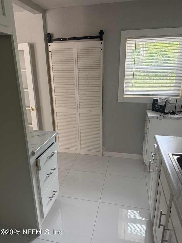 7205 Linda Dr, Jacksonville, FL 32208 - kitchen featuring light tile patterned floors, light countertops, and baseboards