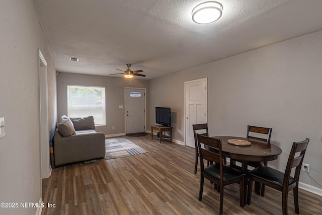 7205 Linda Dr, Jacksonville, FL 32208 - dining space featuring wood finished floors, a ceiling fan, baseboards, and a textured ceiling