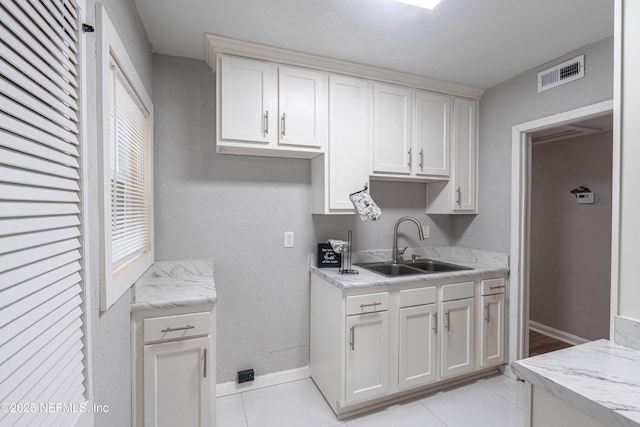 7205 Linda Dr, Jacksonville, FL 32208 - kitchen featuring a sink, baseboards, white cabinets, light tile patterned floors, and plenty of natural light