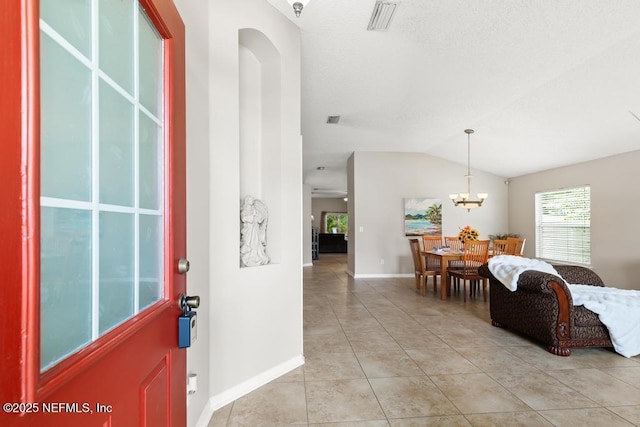 880 W American Eagle Dr, Saint Augustine, FL 32092 - foyer entrance with light tile patterned floors, vaulted ceiling, baseboards, and a chandelier