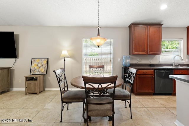 880 W American Eagle Dr, Saint Augustine, FL 32092 - kitchen featuring dishwashing machine, a sink, dark countertops, a textured ceiling, and light tile patterned floors