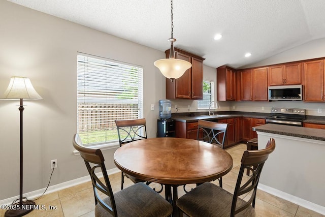 880 W American Eagle Dr, Saint Augustine, FL 32092 - kitchen featuring stainless steel appliances, dark countertops, a textured ceiling, a sink, and hanging light fixtures