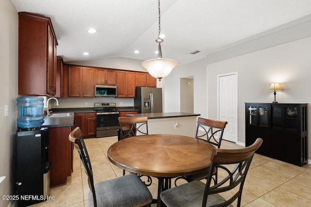 880 W American Eagle Dr, Saint Augustine, FL 32092 - kitchen featuring stainless steel appliances, a sink, dark countertops, light tile patterned floors, and lofted ceiling