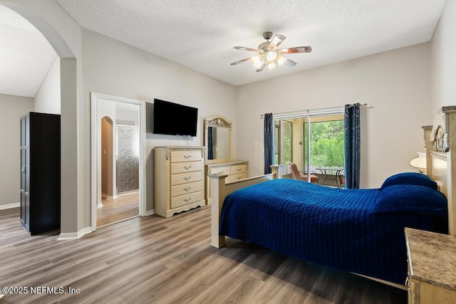 880 W American Eagle Dr, Saint Augustine, FL 32092 - bedroom with arched walkways, light wood-style flooring, a textured ceiling, baseboards, and a ceiling fan