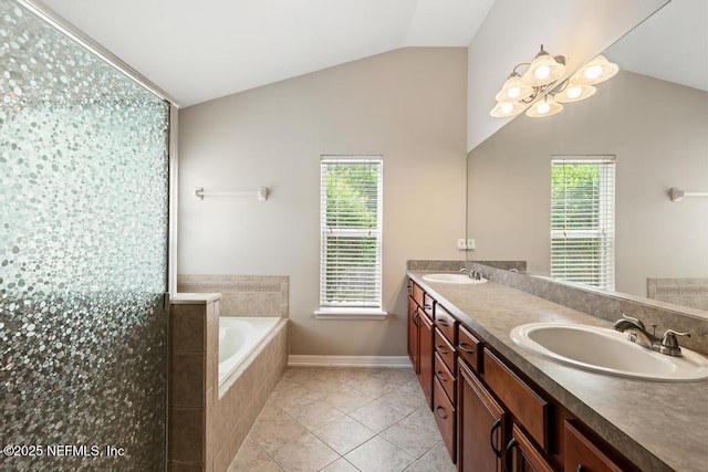 880 W American Eagle Dr, Saint Augustine, FL 32092 - full bathroom featuring vaulted ceiling, double vanity, a garden tub, tile patterned floors, and baseboards