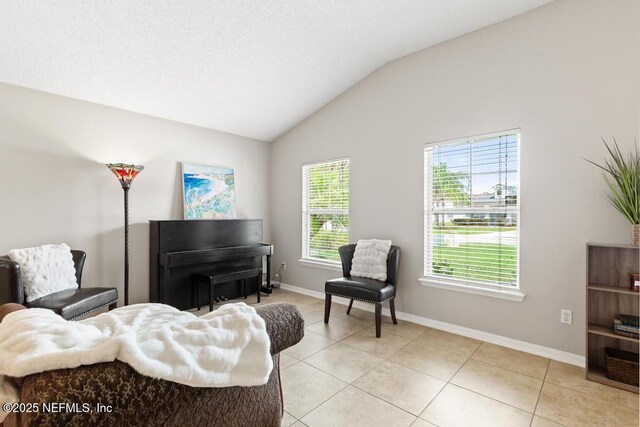 880 W American Eagle Dr, Saint Augustine, FL 32092 - living area featuring lofted ceiling, light tile patterned floors, and baseboards