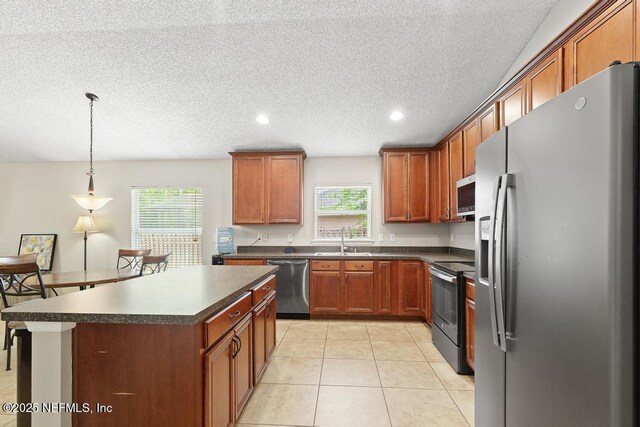 880 W American Eagle Dr, Saint Augustine, FL 32092 - kitchen featuring appliances with stainless steel finishes, a sink, dark countertops, plenty of natural light, and a textured ceiling