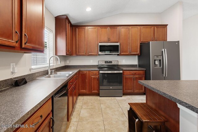 880 W American Eagle Dr, Saint Augustine, FL 32092 - kitchen featuring appliances with stainless steel finishes, a sink, dark countertops, vaulted ceiling, and light tile patterned floors