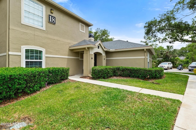 view of front of property featuring stucco siding and a front yard