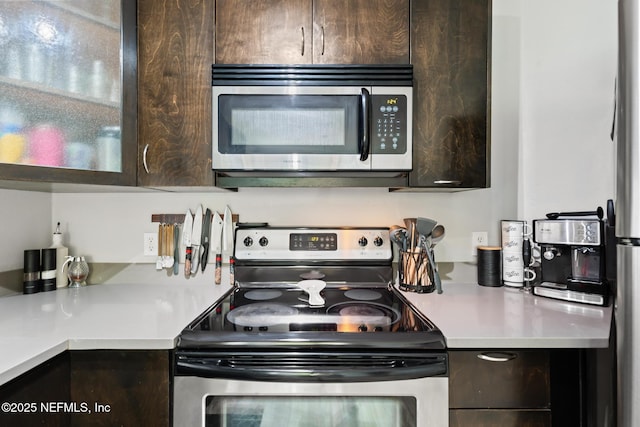 kitchen featuring appliances with stainless steel finishes, dark brown cabinetry, and light countertops