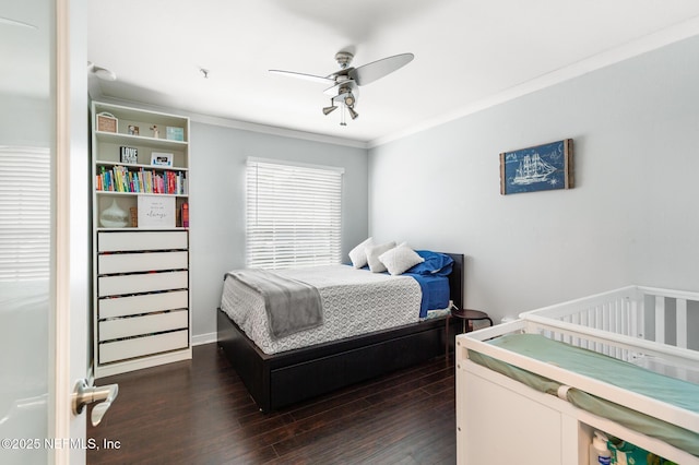 bedroom featuring dark wood-style floors, ornamental molding, and a ceiling fan