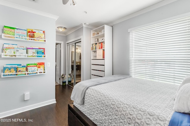 bedroom featuring ornamental molding, wood finished floors, baseboards, a closet, and a ceiling fan