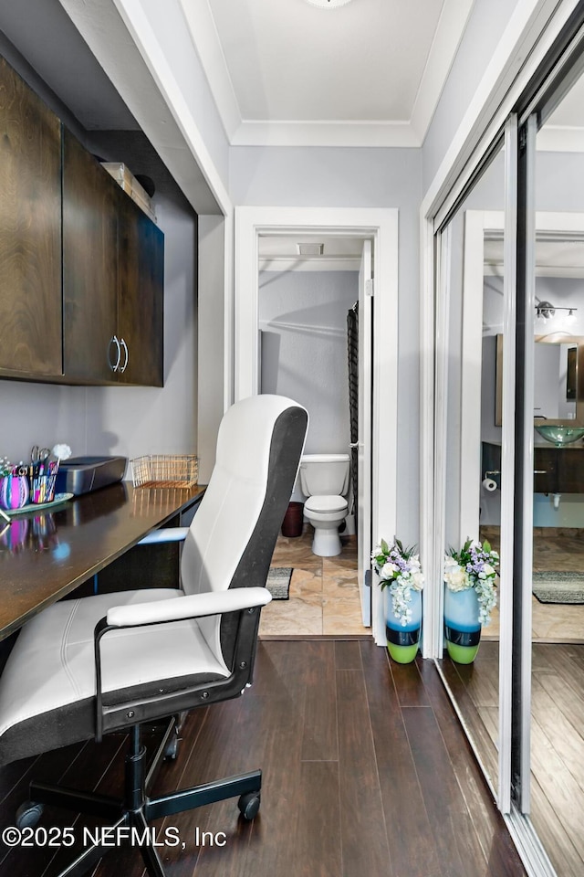 home office with dark wood-style flooring and ornamental molding